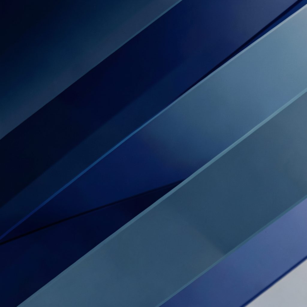 An abstract image of layered translucent shapes in navy and slate blue, evoking the transfer of knowledge and technology